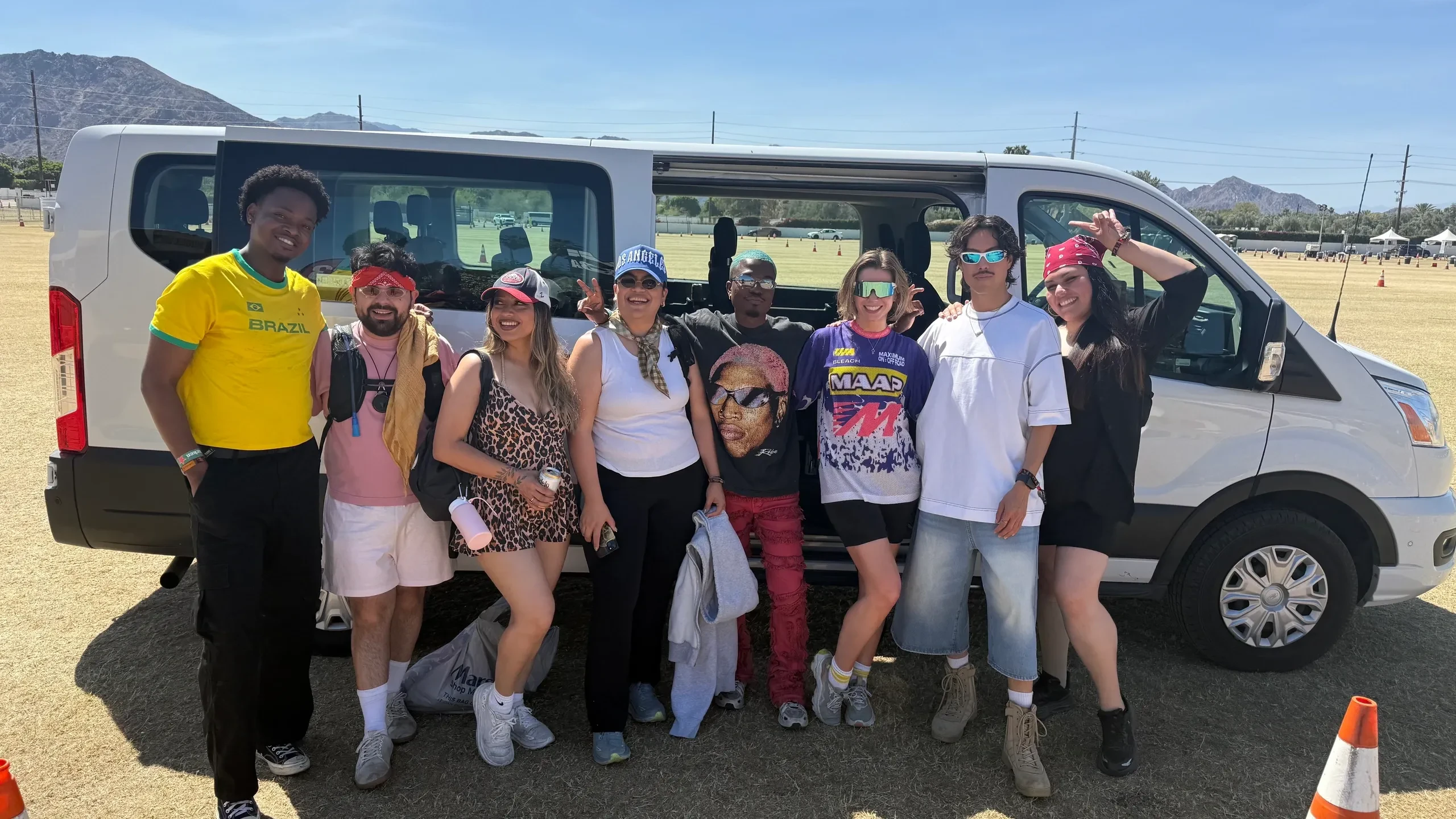 Group of Coachella festival guests posing in front of passenger van
