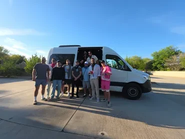 Group of Coachella guests in front of white Sprinter van